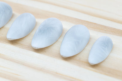 Icy white/silver cat eye press on nails that mimic the look of a frosty window, featured on a wooden background