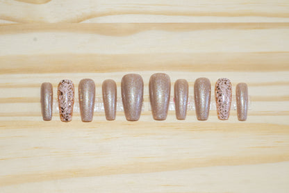 Shimmery champagne gold press on nails with glittery gold accent nails featured on a wooden background