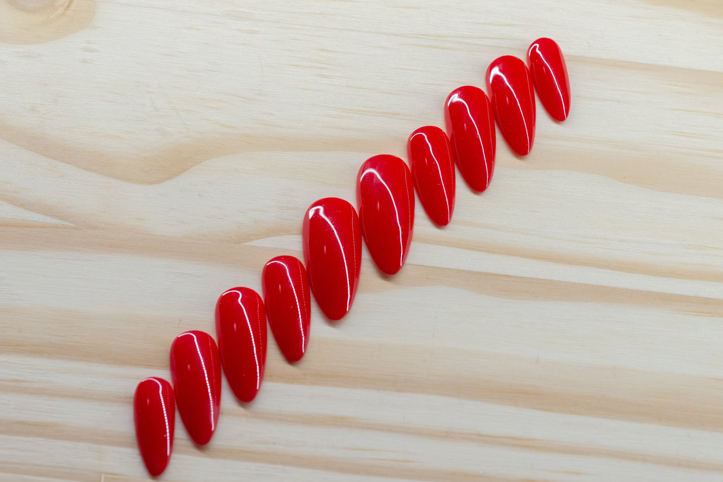 classic red press on nails featured on a wooden background