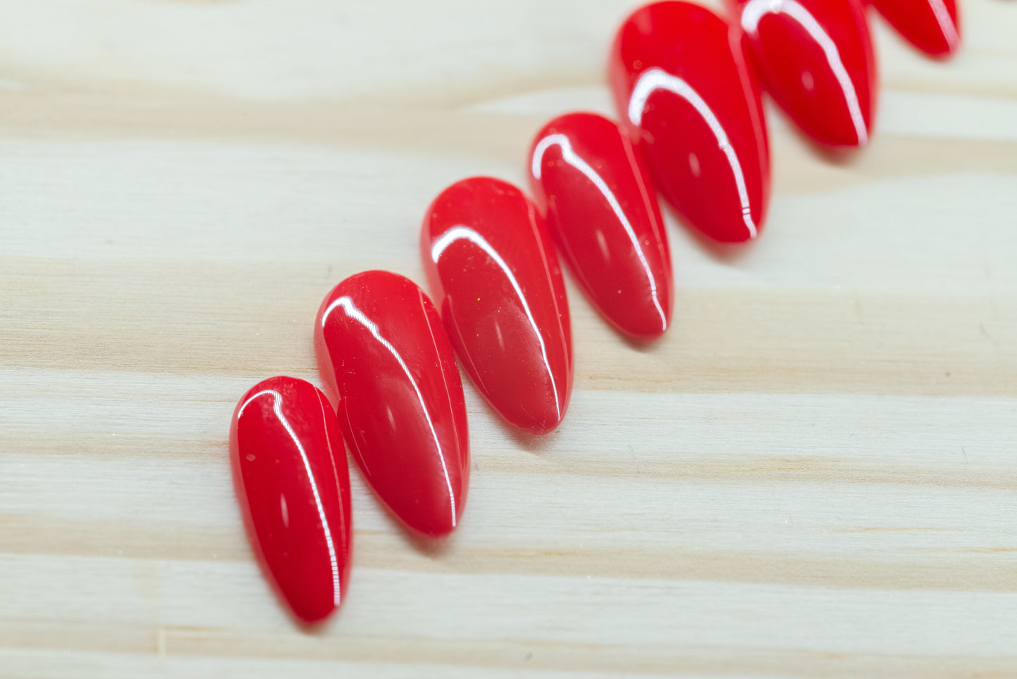 classic red press on nails featured on a wooden background