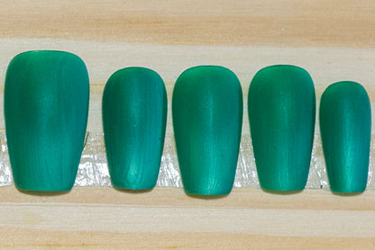 Wintergreen cat eye press on nails with matte finish featured on a wooden background