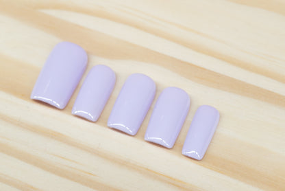 Set of pale lilac press on nails featured on a wooden background
