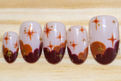Press on nails in sunset colors with stars on a wooden background