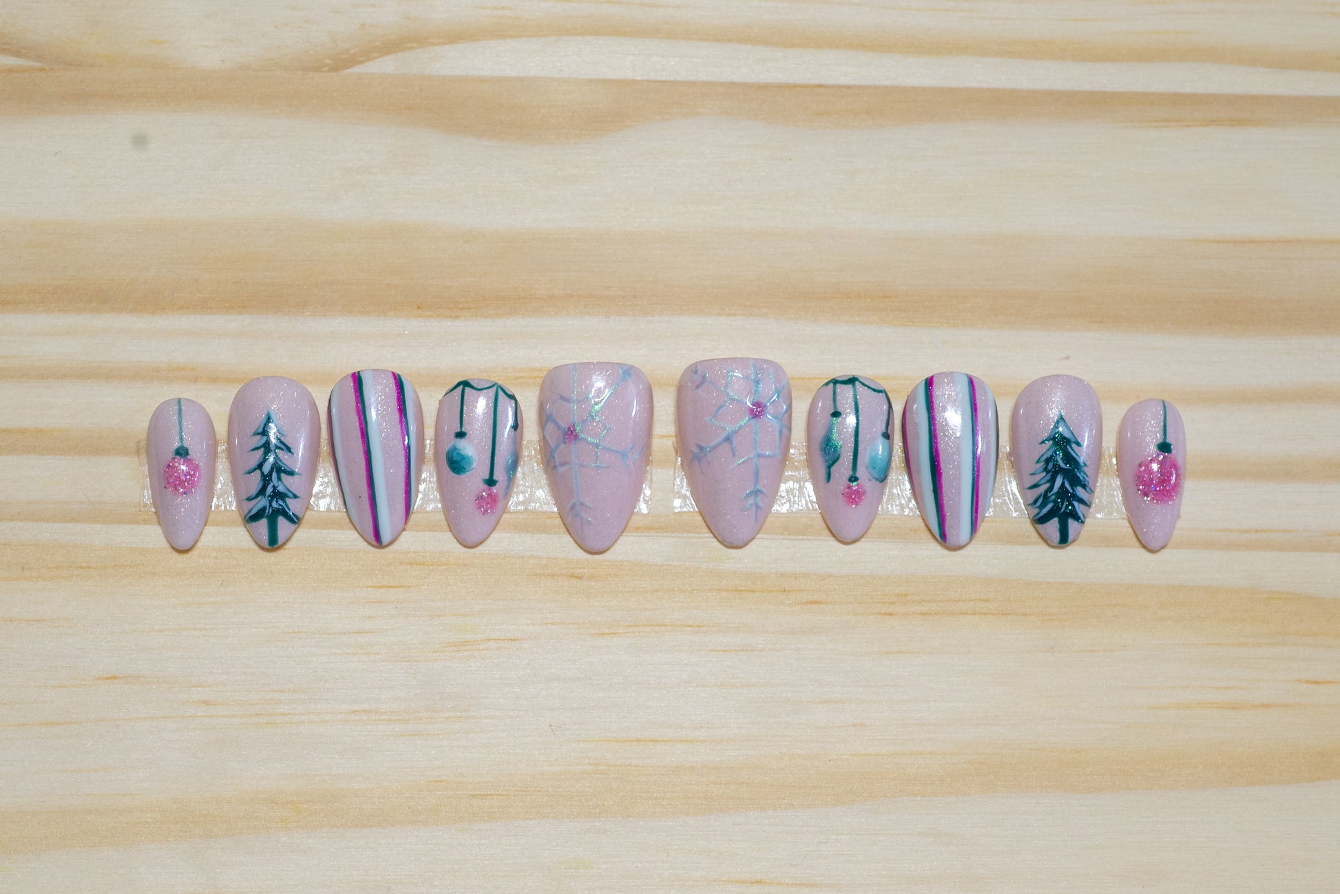 Christmas holiday press on nails with mid-century pastel theme on a wooden background